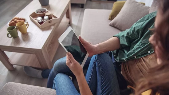 Couple sitting on a couch with a tablet